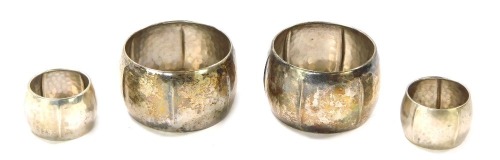 Four hammered napkin rings, comprising two large and two small white metal, stamped 800, 9¼oz, in K Compaan boxes.