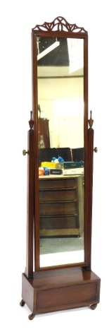 A 20thC mahogany cheval mirror, with a fret carved above a rectangular mirror plate and brass tightening wheels and a single drawer, on castors, 124cm high, 45cm wide, 23cm deep.