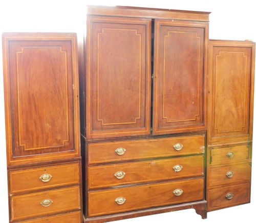 A 19thC mahogany cross banded wardrobe, the central section with two swing doors over three long drawers, on bracket feet with moulded cornice, and two associated single pine panels with door and three drawers, label for Amy Kesteven, the central section