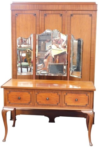 An early 20thC mahogany bedroom suite, comprising triple wardrobe and dressing table, the dressing table with three long drawers on out splayed feet, 200cm high, 122cm wide, 155cm deep, the wardrobe with ebonised handles, on bracket feet, 193cm high, 133c