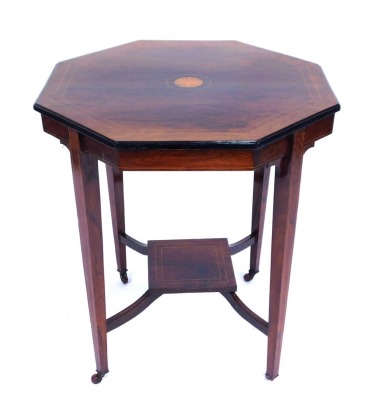 An Edwardian rosewood octagonal occasional table, with strung outer border and shelf centre, on square set base on tapered legs terminating in castors, 69cm high, the top 61cm x 61cm.