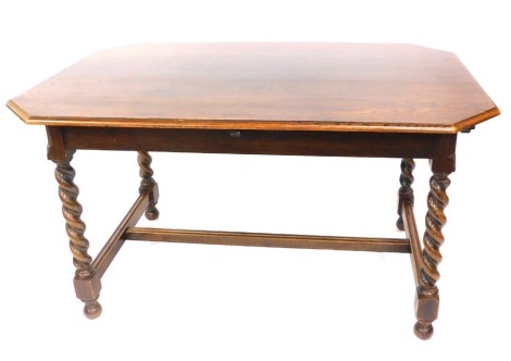 An oak dining table, the rectangular top with canted corners on a H frame base with twist column supports on bun feet, 76cm high, 134cm wide, 88cm deep.