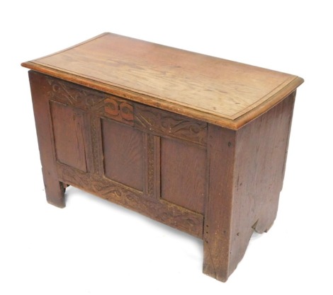 A late 17thC oak coffer, the later top above three panels, with floral carved supports on stiles, adapted, 60cm high, 86cm wide, 46cm deep.