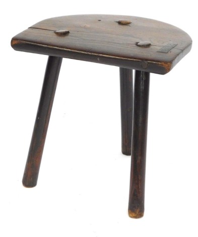 A 19thC elm and pine milking stool, with a shaped seat on turned legs, the legs later, 40cm high, 41cm wide, 32cm deep.