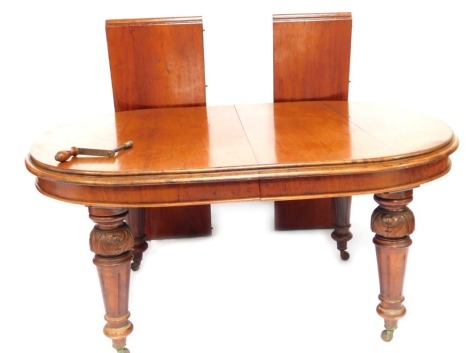 A 19thC mahogany extending dining table, with rounded ends on heavy baluster legs terminating in ceramic castors, 75cm high, 140cm wide, 115cm deep and two additional leaves.