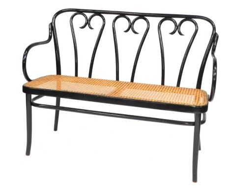 A bentwood sofa, with three arch back, in black with a caned seat, 85cm high, 114cm wide, 46cm deep.