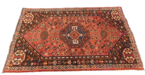 A Persian rug, in red and blue, with central large medallion and four medallions to corners, 160cm x 102cm.