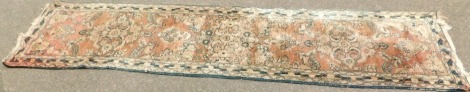 An Eastern runner, with three central floral panels in red, cream and blue, 310cm x 83cm. (AF)