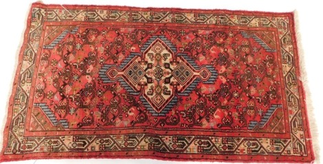 A Persian rug, with central medallion and red border, reduced, 130cm x 72cm.