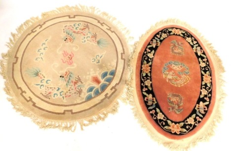 Two Chinese circular wool cut rugs, oval example 135cm x 88cm, round example 130cm diameter. (2)