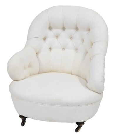 A Victorian button back bedroom chair, in cream upholstery with turned legs and castors, 82cm high.