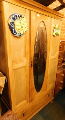 A pine single wardrobe, with central glazed door and applied sun crest, with single drawer.