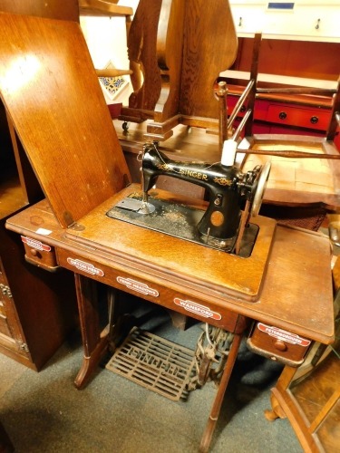 An oak Singer treadle sewing machine and stand, serial number EA452461 with applied railway station badges.