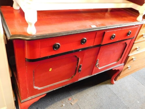 A red and black painted sideboard, with two drawers and two cupboard doors, on cabriole legs.