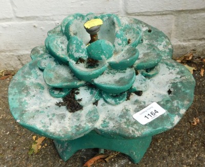 A green painted reconstituted stone lily pad water feature.