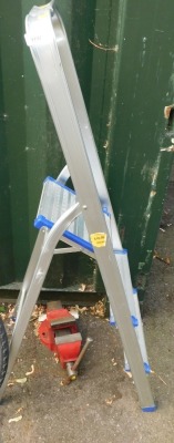 An aluminium three tier stepladder and a red bench vice. (2)