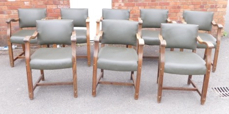 A set of eight oak framed carver chairs, each with a green studded leatherette seat, 84cm high, 55cm wide, 45cm deep.