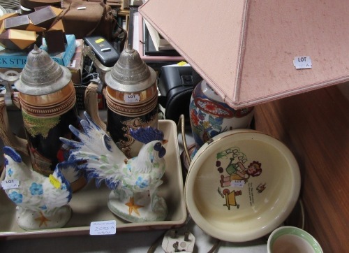 Two beer steins, lamp, childs dish and two cockerels.