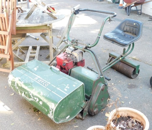 A vintage petrol Atco mower, roller with seat attachment and roller. (a quantity)