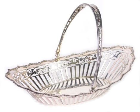 A George V silver basket, by James Dixon, of oval form with pierced swing handle, pierced body, decorated with scrolls and flower heads, Sheffield 1928, 24cm wide, 11.16oz. 