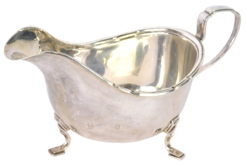 A George VI silver sauce boat, by Walker and Hall, of cape form on stepped feet with angular handle, Sheffield 1947, 9cm high, 3.74oz.