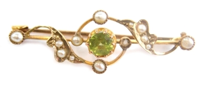 An Edwardian peridot and pearl brooch, with entwined decoration and plain back, 3cm long. (cased) - 2