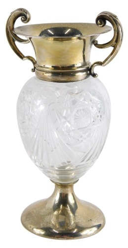 An Edward VII silver and cut glass two handled vase, with scroll handles, shaped body, inverted stem and circular foot, Birmingham 1908, 18cm high.