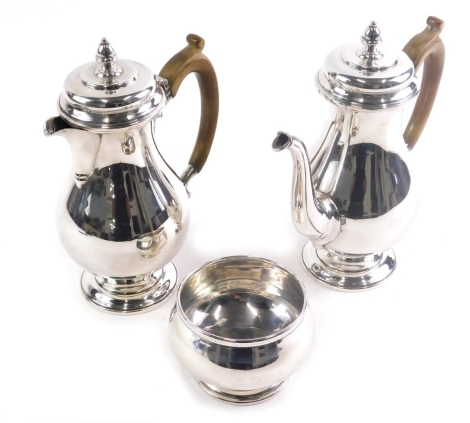 A George VI silver piece coffee service, by CE, comprising coffee pot, with acorn finial, moulded handle, shaped body and circular foot, 21cm high, similar water jug and sugar bowl, London 1940, 32oz all in. (3)