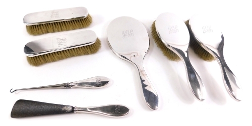 A Victorian silver dressing table set, by Comyns & Sons, comprising hand mirror, 28cm high, button hook, shoe horn, two clothes brushes and two hairbrushes, London 1899. (7)