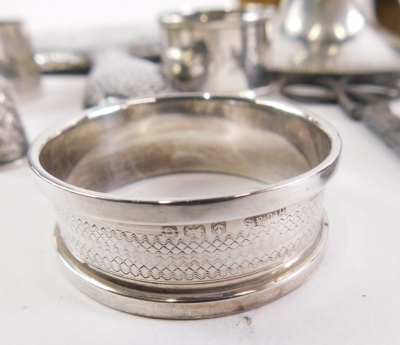 Silver and effects, an Edward VII silver pin dish, of heart shaped form with repousse decorated scrolls and piercing, Birmingham 1903, 10cm wide, various other items, napkin rings, scissors, silver topped jar, part dressing table sets, inkwell and a photo - 3