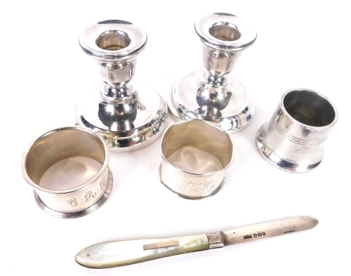 A Edward VII silver and mother of pearl fruit knife, with folding blade, Sheffield 1904, a pair of dwarf candlesticks, two napkin rings, open salt, 12oz all in. (a quantity)