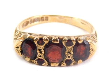 A 9ct gold dress ring, set with four large and four small garnets, size K.