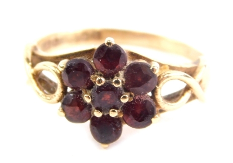 A 9ct gold dress ring, claw set with a floral arrangement of red stones, size J, 2.2g.