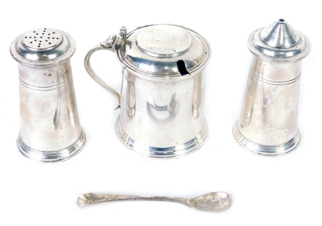 A George V silver three piece cruet set, by Viners, comprising mustard pot with blue glass liner, 8cm high, pepper pot and salt pot, each of plain design, with associated spoon, Sheffield 1928 and 1929, 10oz all in.