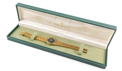 A Gucci fashion watch, with gold plated bracelet, with extra links in case.