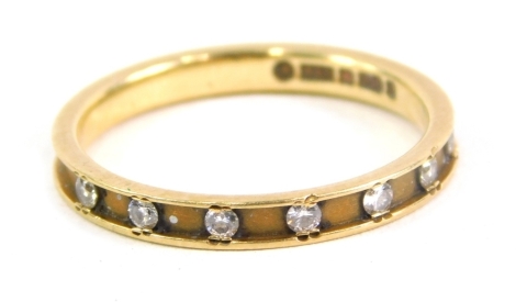 An 18ct gold band, set with small diamonds, size M, 2g all in.