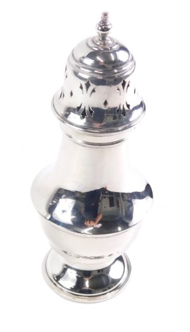 A George V silver sugar caster, with urn finial, pierced dome lid inverted bellied body and inverted foot, Birmingham 1934, 20cm high, 4oz.