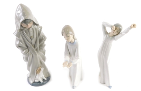 Various Lladro figures, comprising a Daisa figure of a girl A-28, 22cm high, Nao Girl Yawning and another of a Child in Hood aside Puppy. (3)