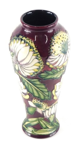 A Moorcroft pottery vase by S Hayes, decorated with flowers on red ground, marked beneath, 27cm high, with associated box and bag.