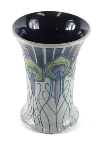 A Moorcroft pottery vase, of shaped form decorated with stylised peacock feathers, impressed and printed marks beneath, 18cm high.