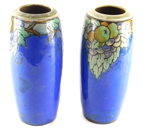 A pair of Royal Doulton Lambeth vases, numbered 8530, sgraffitto decorated with fruit on blue ground, impressed and printed marks beneath, 25cm high. (2)