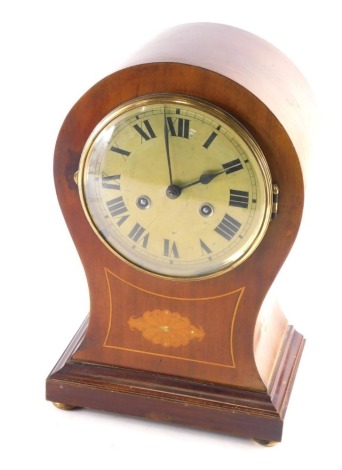 An Edwardian mahogany balloon clock, with 16cm diameter Roman numeric dial, floral inlay, compressed orb feet and eight day movement, 33cm high.