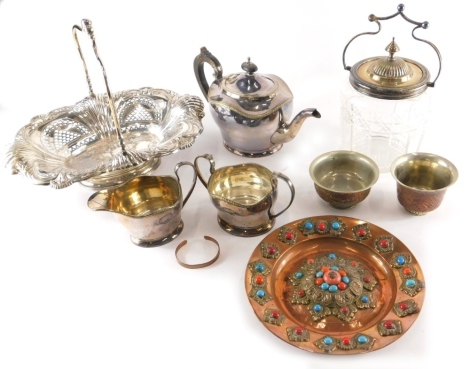 Various silver plated ware, glassware, etc., an early 20thC glass biscuit barrel with silver plated mounts and elaborate handle, 17cm high, teapot, pierced basket with swing handle, an Eastern copper dish with jewelled decoration, part tea service, etc. (