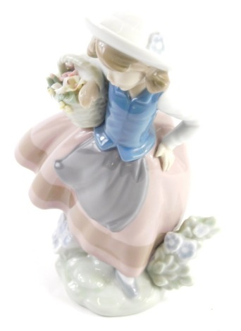 A Lladro figure of a girl holding basket, number 5221, marked beneath, 19cm high.