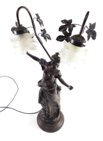 An Art Nouveau style bronze finish two branch table lamp, formed with a semi clad female stem, with entwined floral back on stepped base, 82cm high.