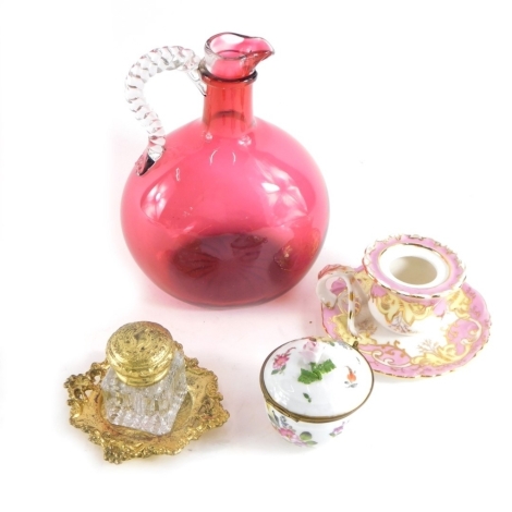 Porcelain and glassware, comprising a cranberry and clear glass ewer, glass inkwell, a Dresden porcelain box and cover, with floral knop hand painted with other flowers with gilt mounts, 8cm high. (4)