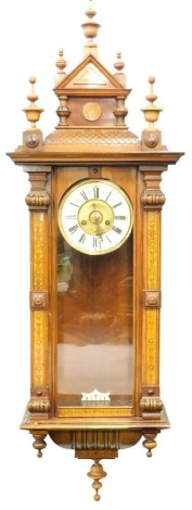 A highly elaborate aesthetic late 19thC Vienna style wall clock, the 14cm diameter Roman numeric dial surmounted by shaped finials and flanked by scrolls, with floral columns, with eight day movement and pendulum, 96cm high.