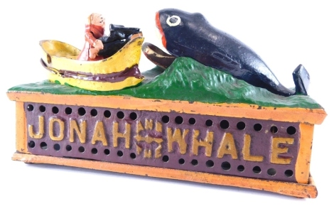 A metal articulated Jonah and the Whale money bank, 25cm wide.