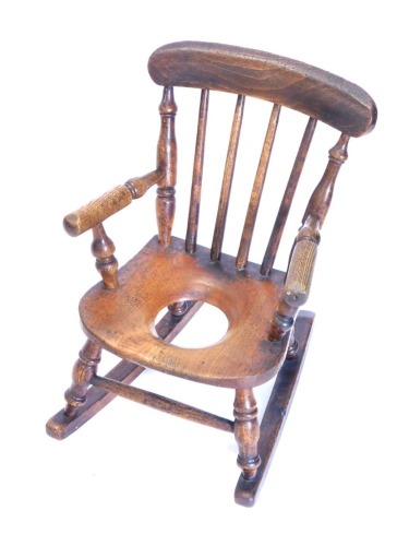 A 19thC child's ash and elm rocking commode Windsor chair, with turned supports, 36cm wide.