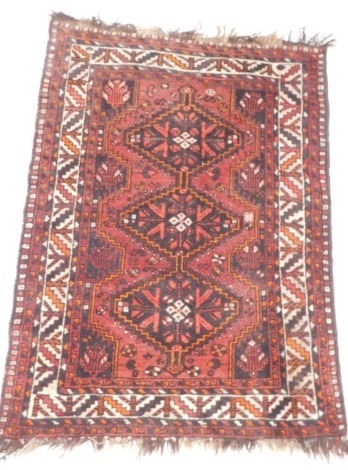 A Persian rug, with a central pole medallion, on a deep red ground with one wide and various narrow borders, 146cm x 113cm.